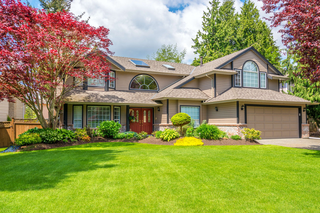 A large house with a lush green lawn in front of it.