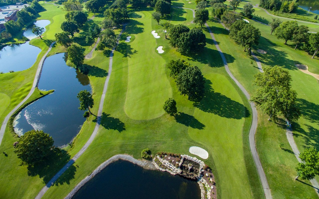 An aerial view of a golf course with lush green fairways