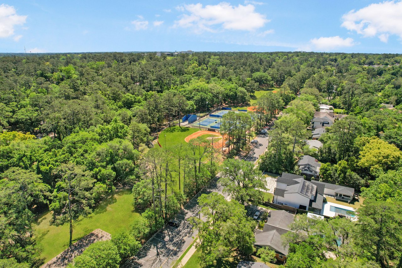 An aerial view focusing on the residential area of Betton Hills, showcasing houses, streets, and surrounding greenery.