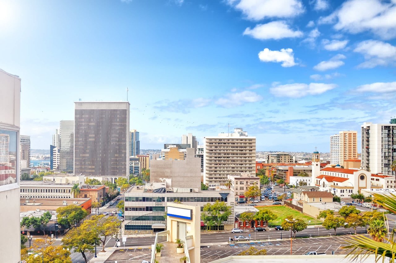 Downtown skyline with a church, surrounding streets, and blue sky.