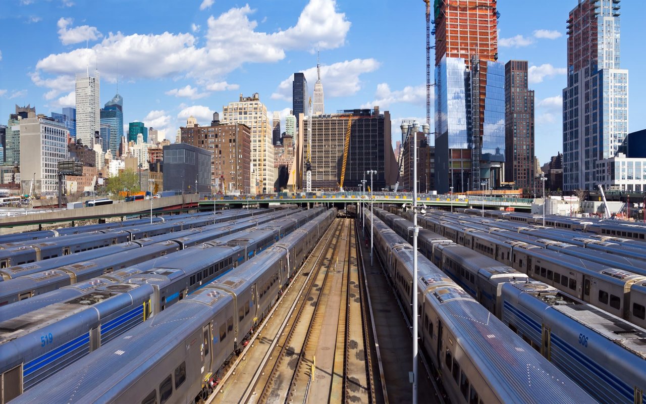 hudson yards trains all in a row, with NYC skyline in the back