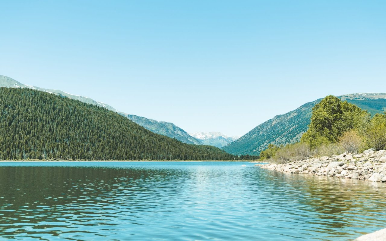 Serene Mountain Lake in the Rocky Mountains, bathed in sunlight.