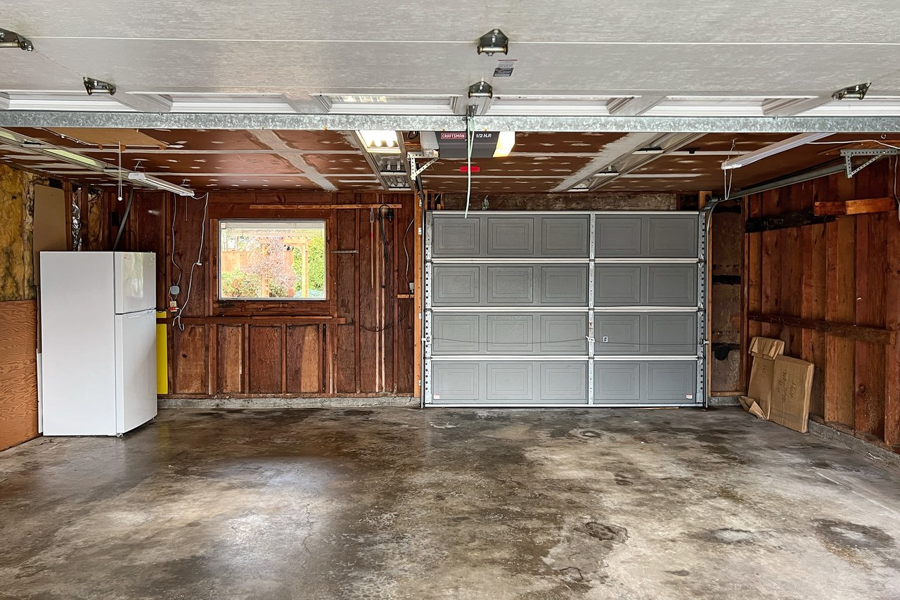 This expansive garage boasts a double door entry at the front and a convenient roll-up door at the back, offering versatile access and functionality for all your storage and project needs.