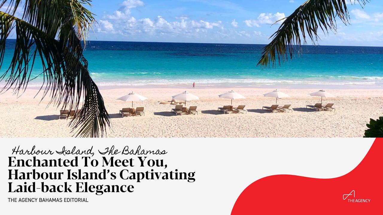 Several white beach umbrellas with lounge chairs are neatly lined up along the shore.