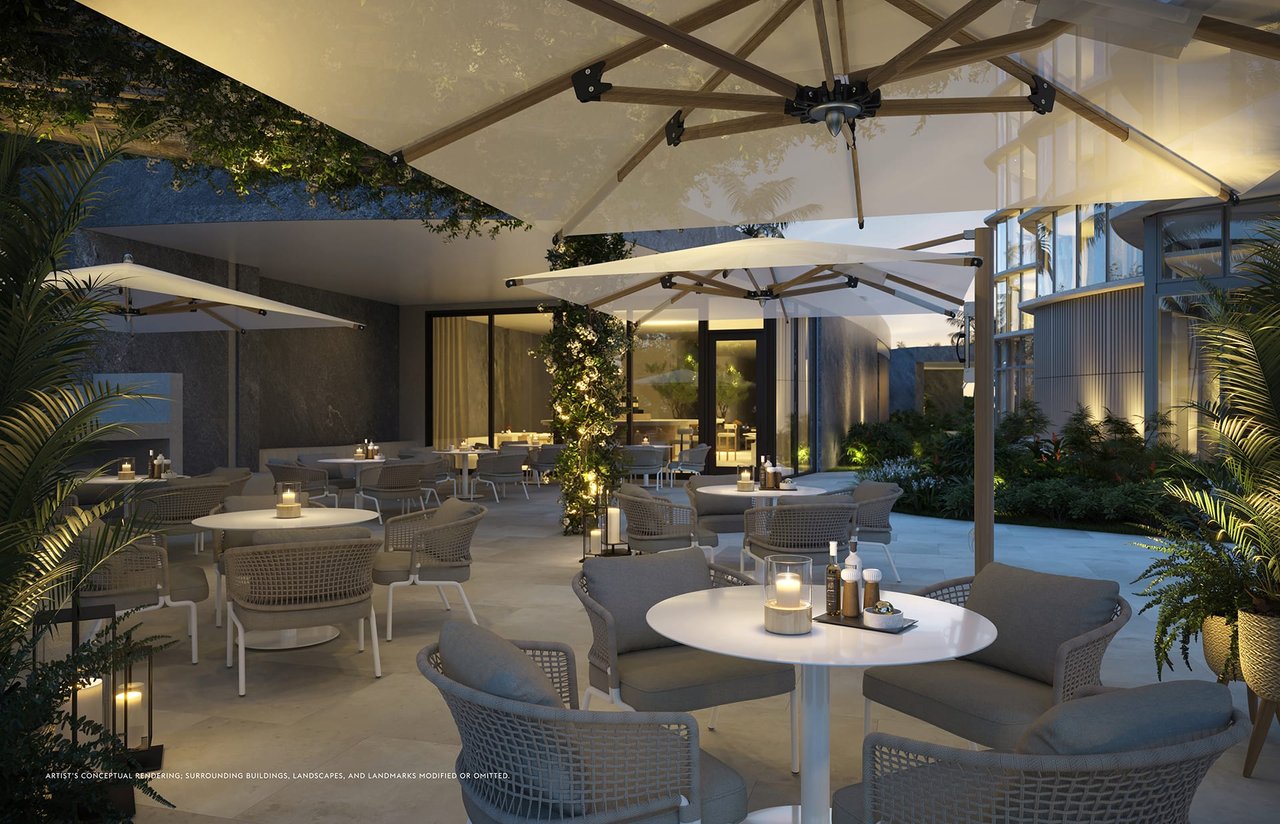 Outdoor terrace with dining tables, wicker lounge seating, oversized umbrellas, and tropical landscaping.