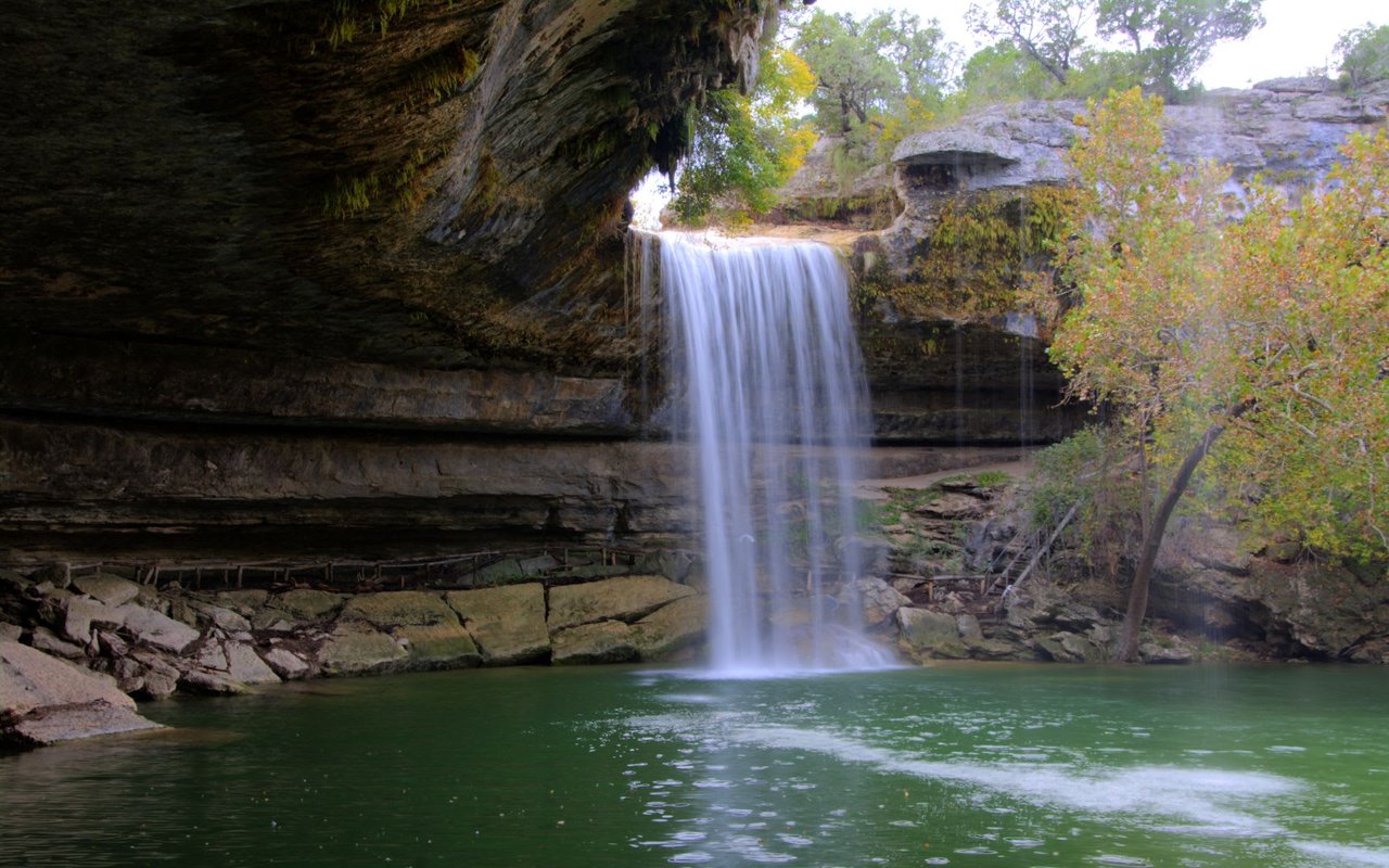 Bee Cave Falls: A scenic waterfall surrounded by lush greenery.