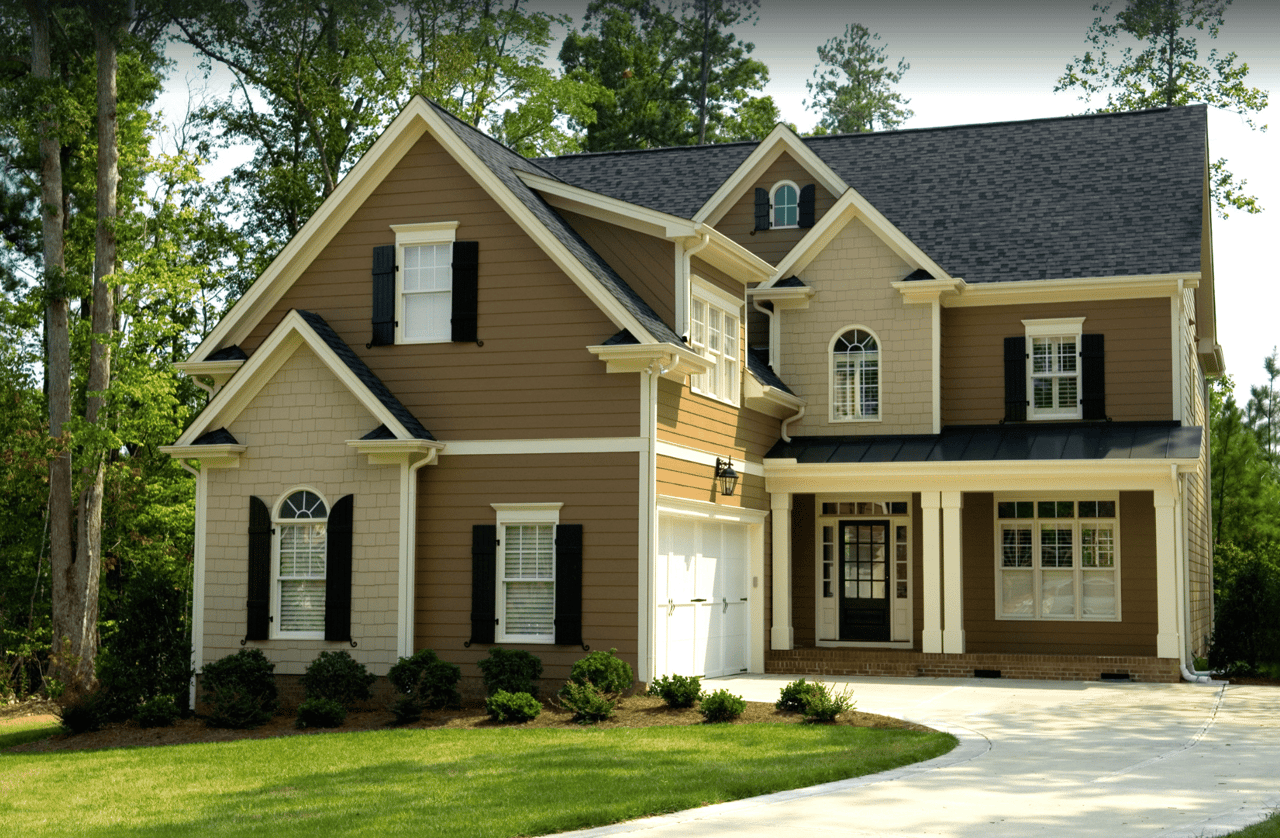 A large brown house with a black roof.