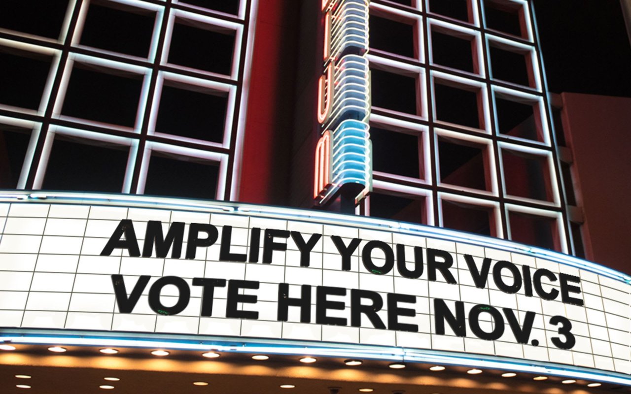 Illuminated venue marquee reads “Amplify your voice, vote here Nov. 3.”