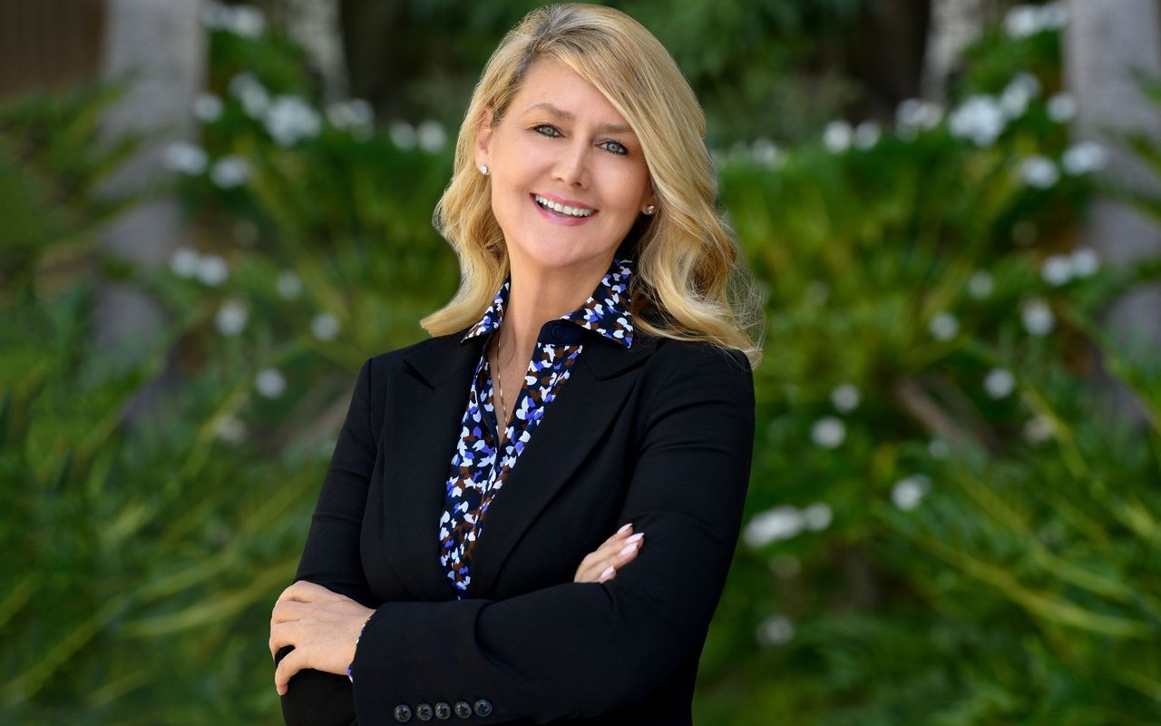 luxury property specialist, Joanne Wheeler wearing a printed blouse and black blazer