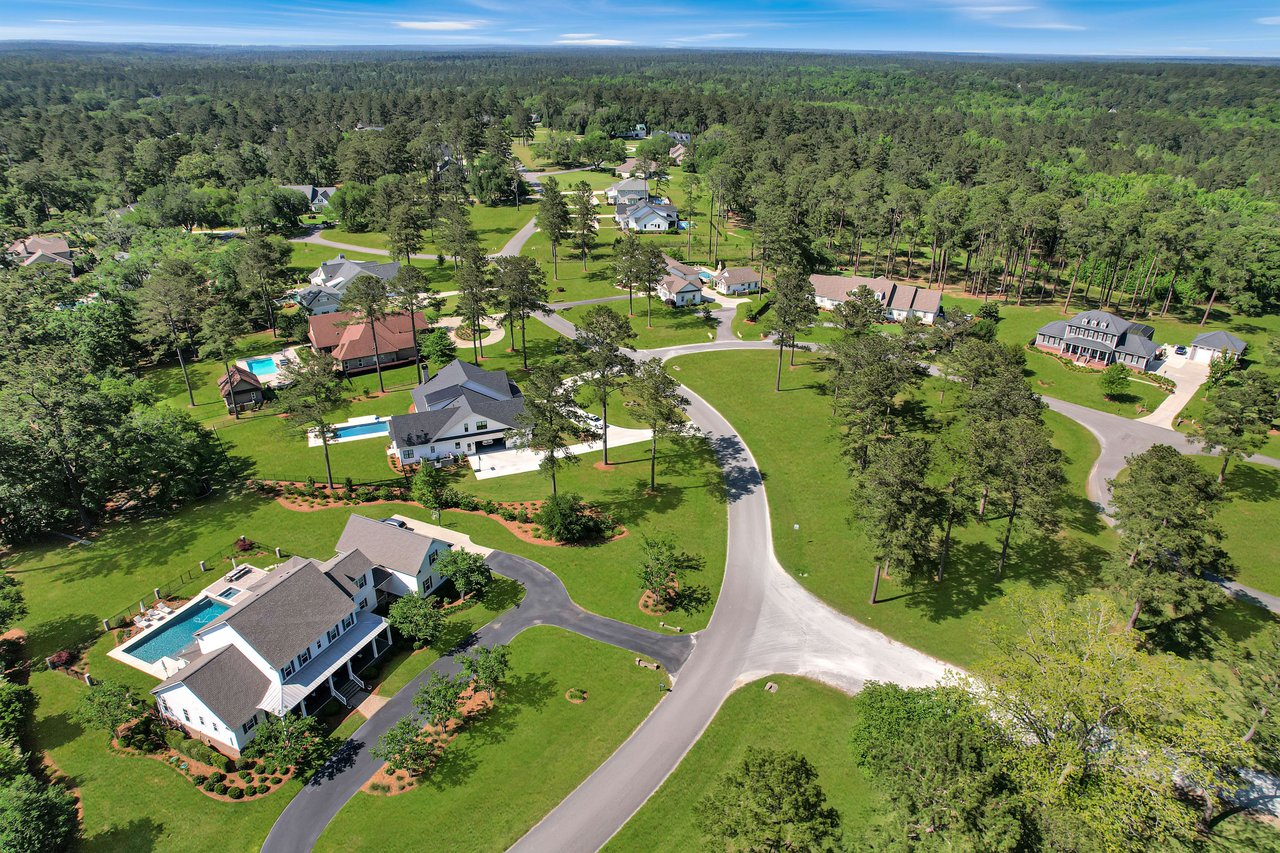 A street view in Centerville Conservation, showing a well-maintained road with trees and houses.