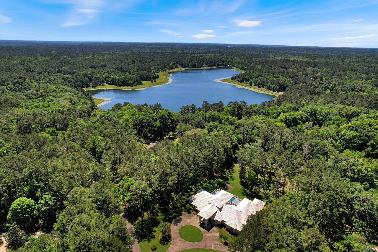 Another aerial view of a residential neighborhood in Rosehill with a lake and houses amidst lush trees.