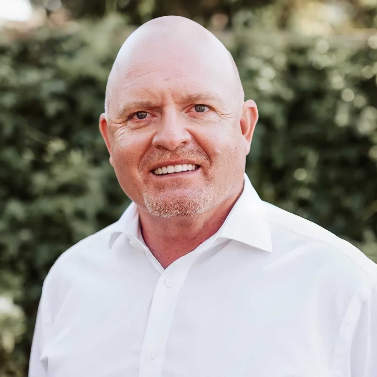 Tim O'Halloran, smiling real estate professional in white shirt.