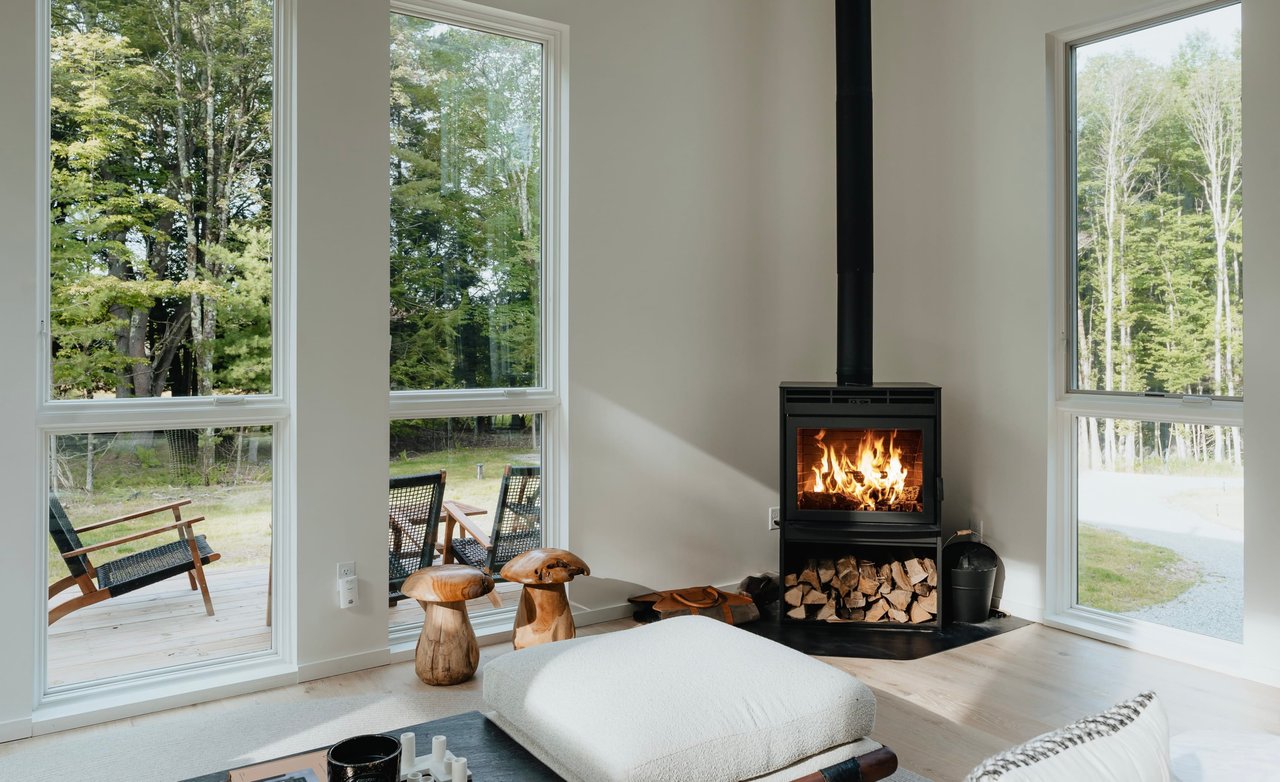  A cozy and modern living space featuring a black freestanding wood-burning stove with a visible fire