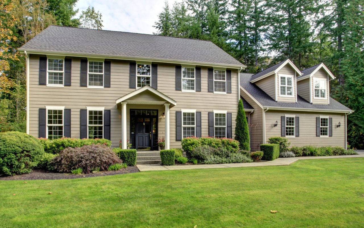 A large house with a green lawn in front of it.