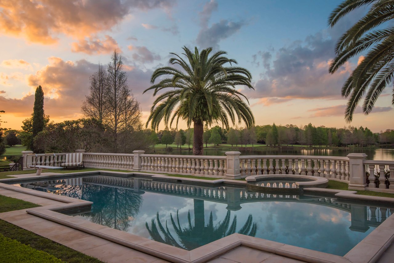 luxury mansion pool at sunset overlooking lake