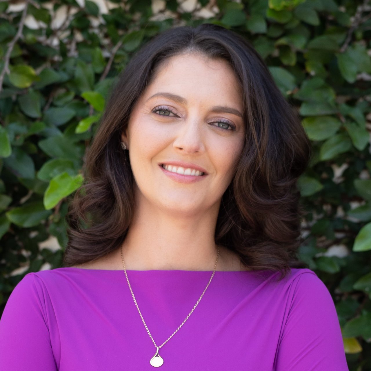 a woman wearing a purple top and smiling