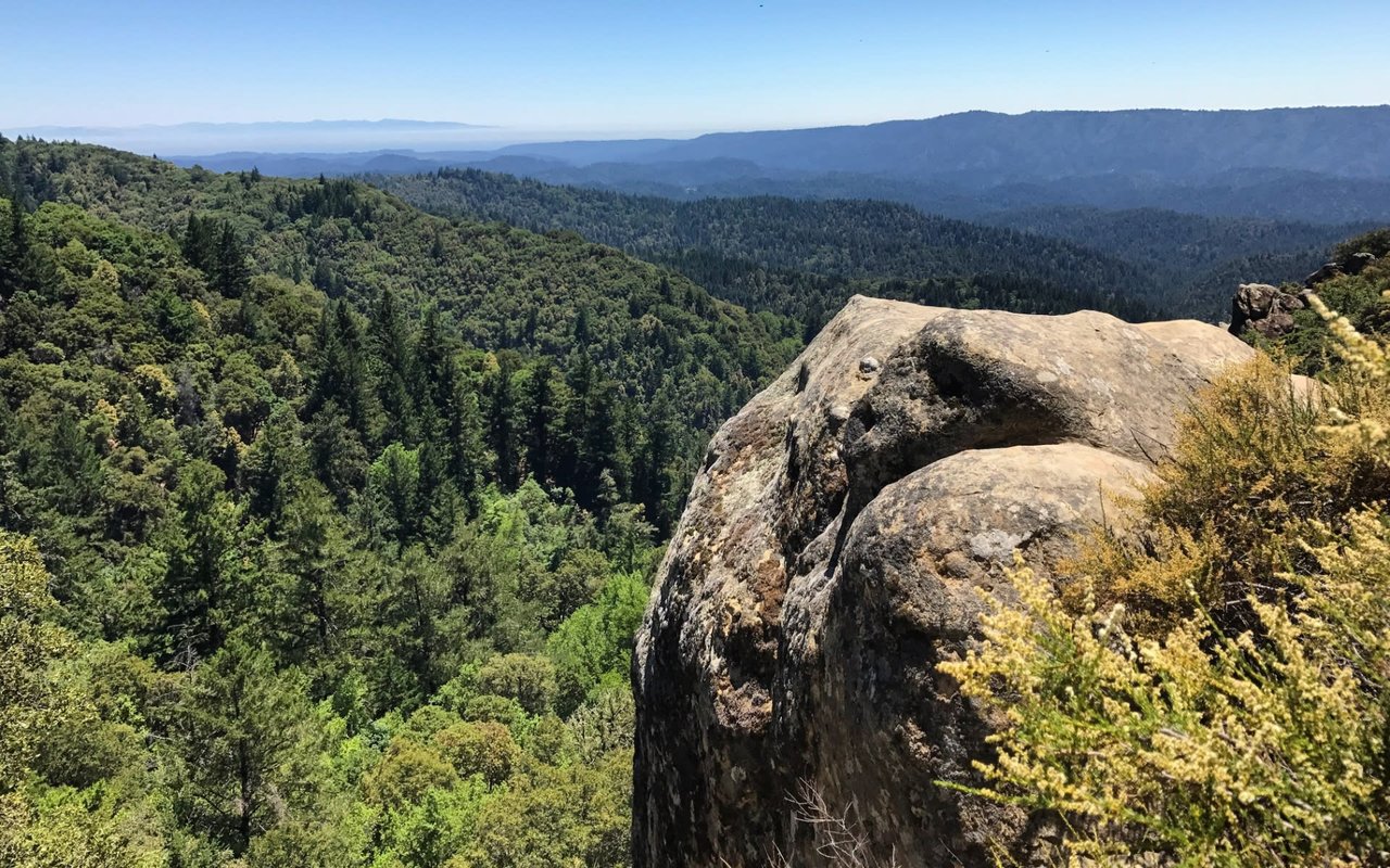 A gray and moss-covered large rock sitting in the middle of Castle Rock State Park in Los Gatos, California.