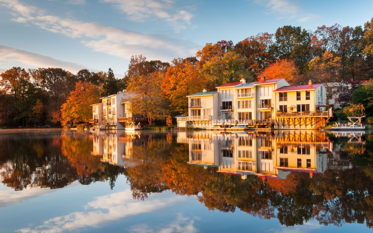 Autumn, sunset scene along a river with sun drenched white houses along the banks of the river