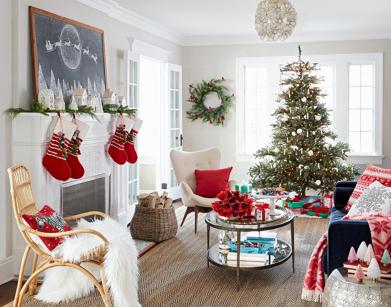Christmas-decorated living room with a lit tree, fireplace stockings, and wreath.