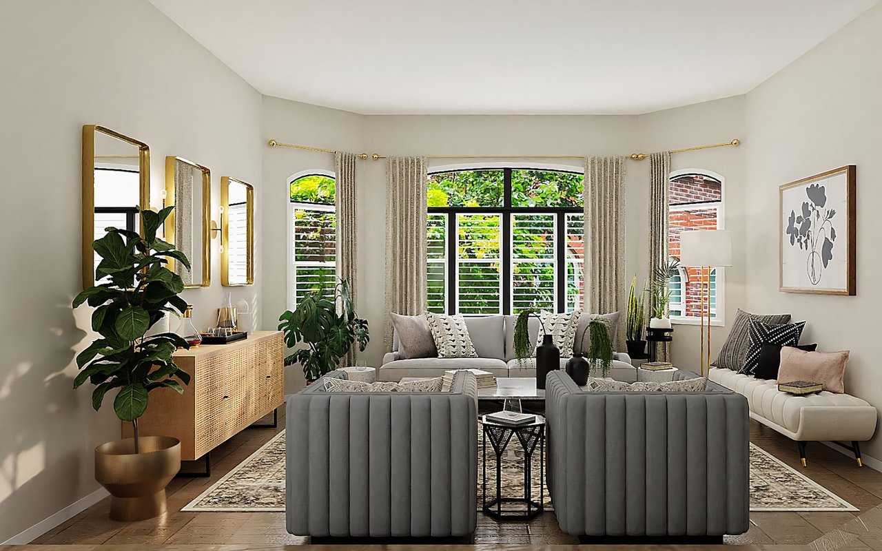 Elegant living room with gray tufted sofas, gold accents, and large windows overlooking a garden.