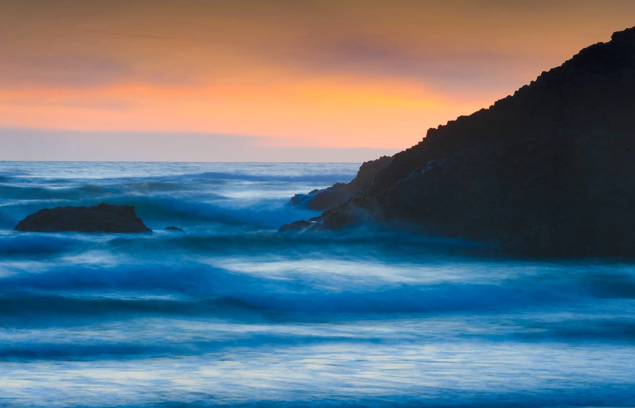 time-laps wave with oranges sunset in arch cape oregon