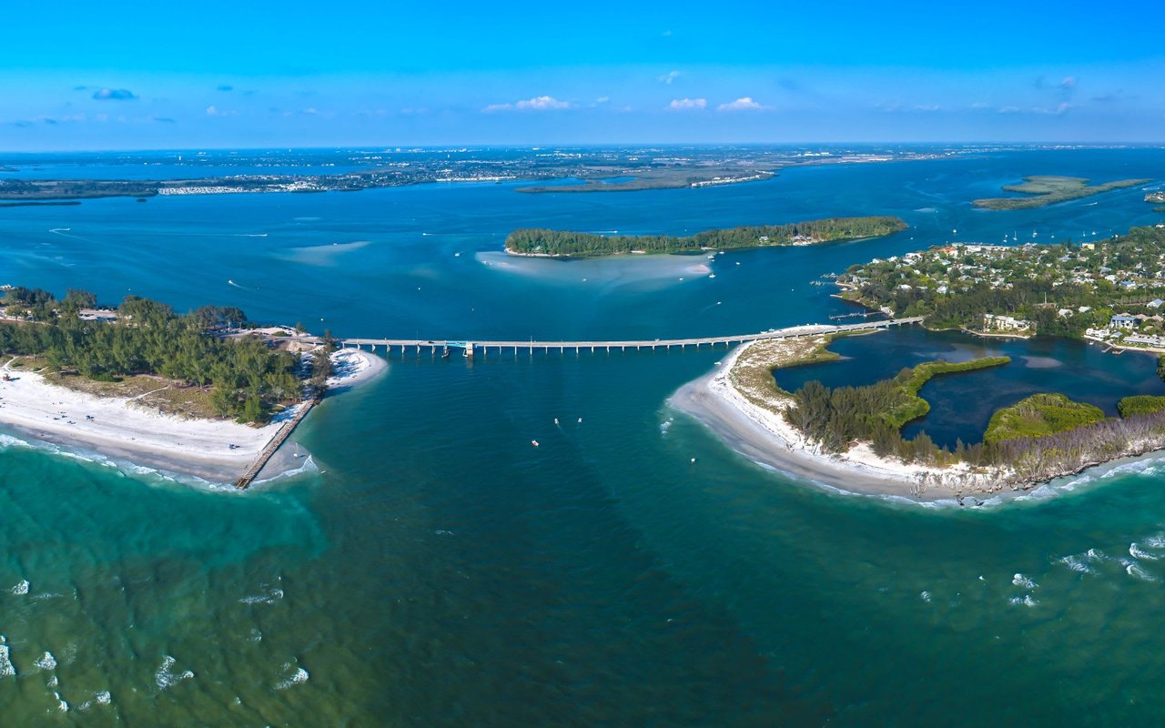  An expansive aerial view captures Longboat Pass, a channel in Florida, with the Longboat Pass Bridge connecting two landmasses