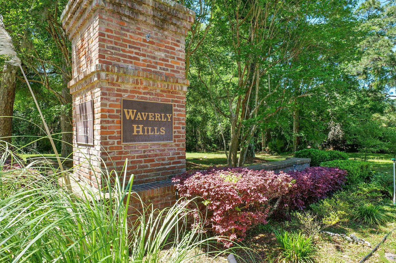 A ground-level view of a brick entrance sign for "Waverly Hills," surrounded by landscaping.