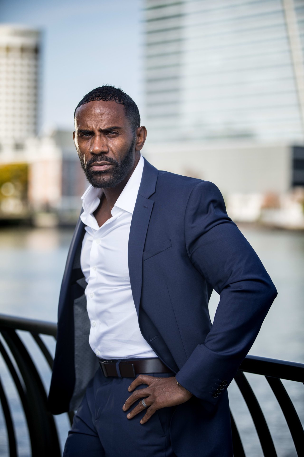 Robert Harris, a real estate professional in a suit, standing near a serene river landscape.