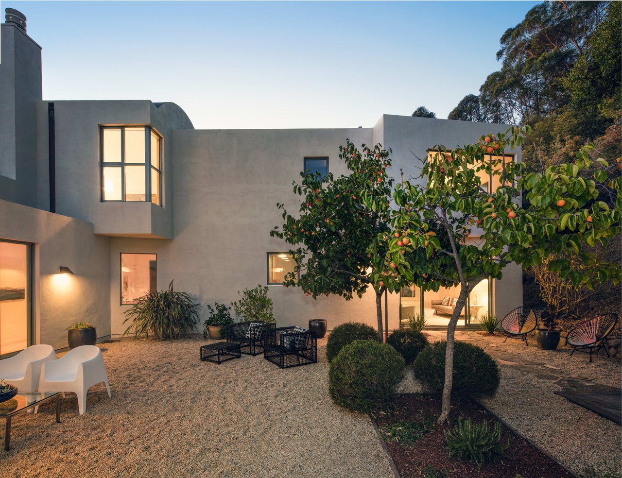 A modern Mediterranean-style home with a curved facade and stucco exterior.