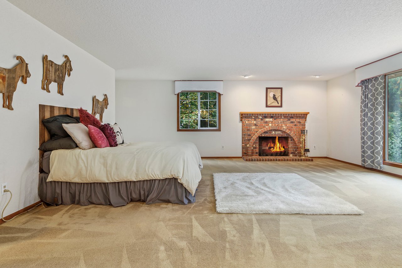 Welcome to the primary bedroom, your personal retreat within this wonderful home. This serene space boasts its own brick fireplace, adding warmth and character to your haven.