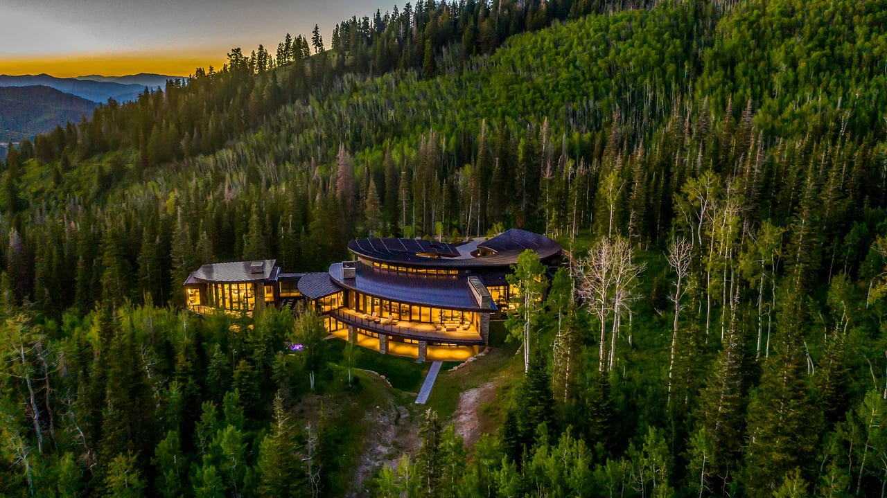 Large, modern house in a forest at dusk