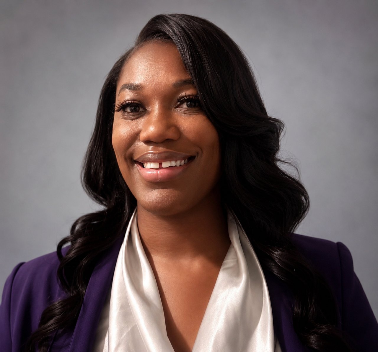 Alexandrea Brigham smiling in a purple blazer and white blouse.