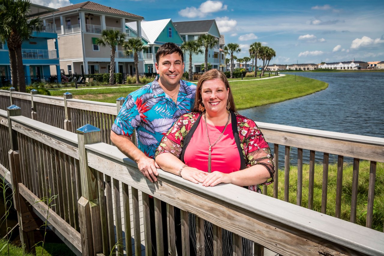 Chad and Suzanne Team, real estate professionals standing on a wooden bridge.