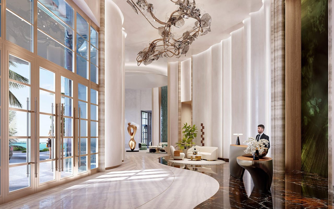 St. Regis Miami Residences lobby with ocean views, curved white seating, and a sculptural chandelier.
