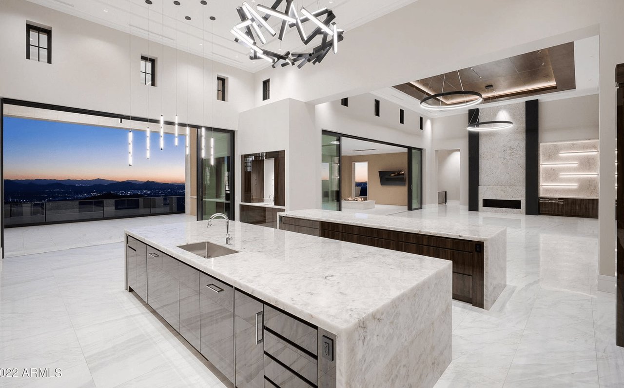 Sleek modern kitchen with expansive mountain views at sunset.