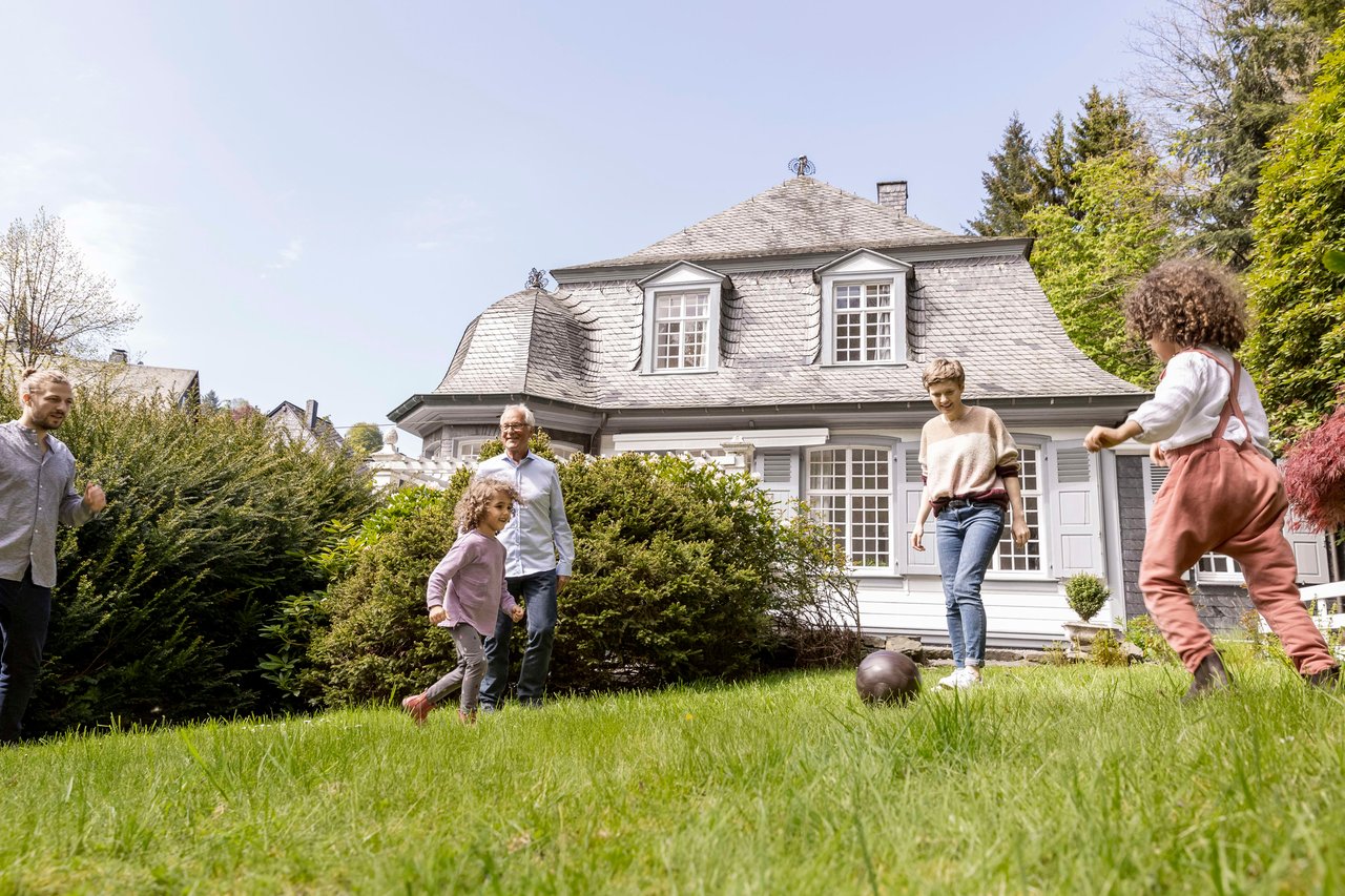 Picture-perfect moments unfold as a joyful family kicks off their day with a friendly soccer match right in front of their warm and inviting home. A scene of togetherness and happiness captured in a snapshot of everyday life.