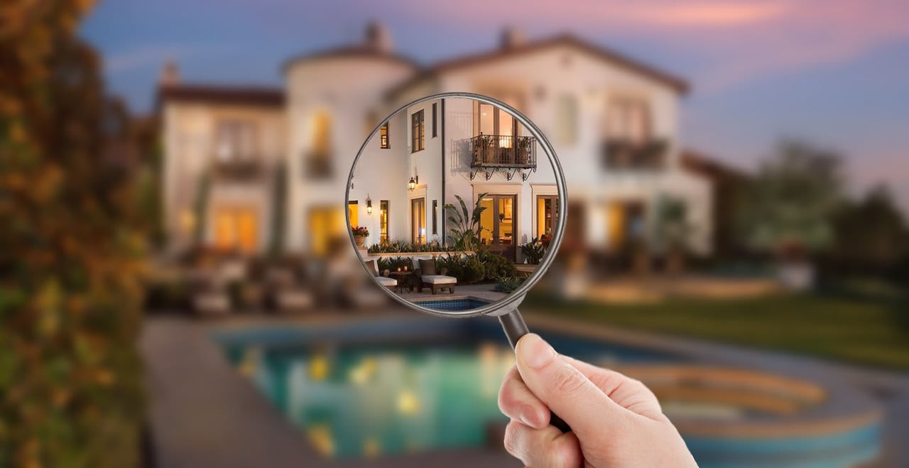House exterior and swimming pool viewed through a magnifying glass at dusk.