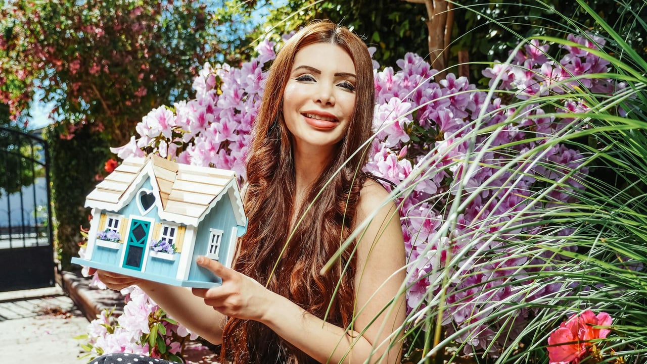 first-time-homebuyer-holding-a-miniature-house-illustrating-she-just-bought-her-first-home