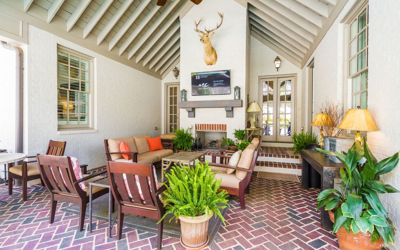 A deer head mounted on a wall above a fireplace in an outside living room