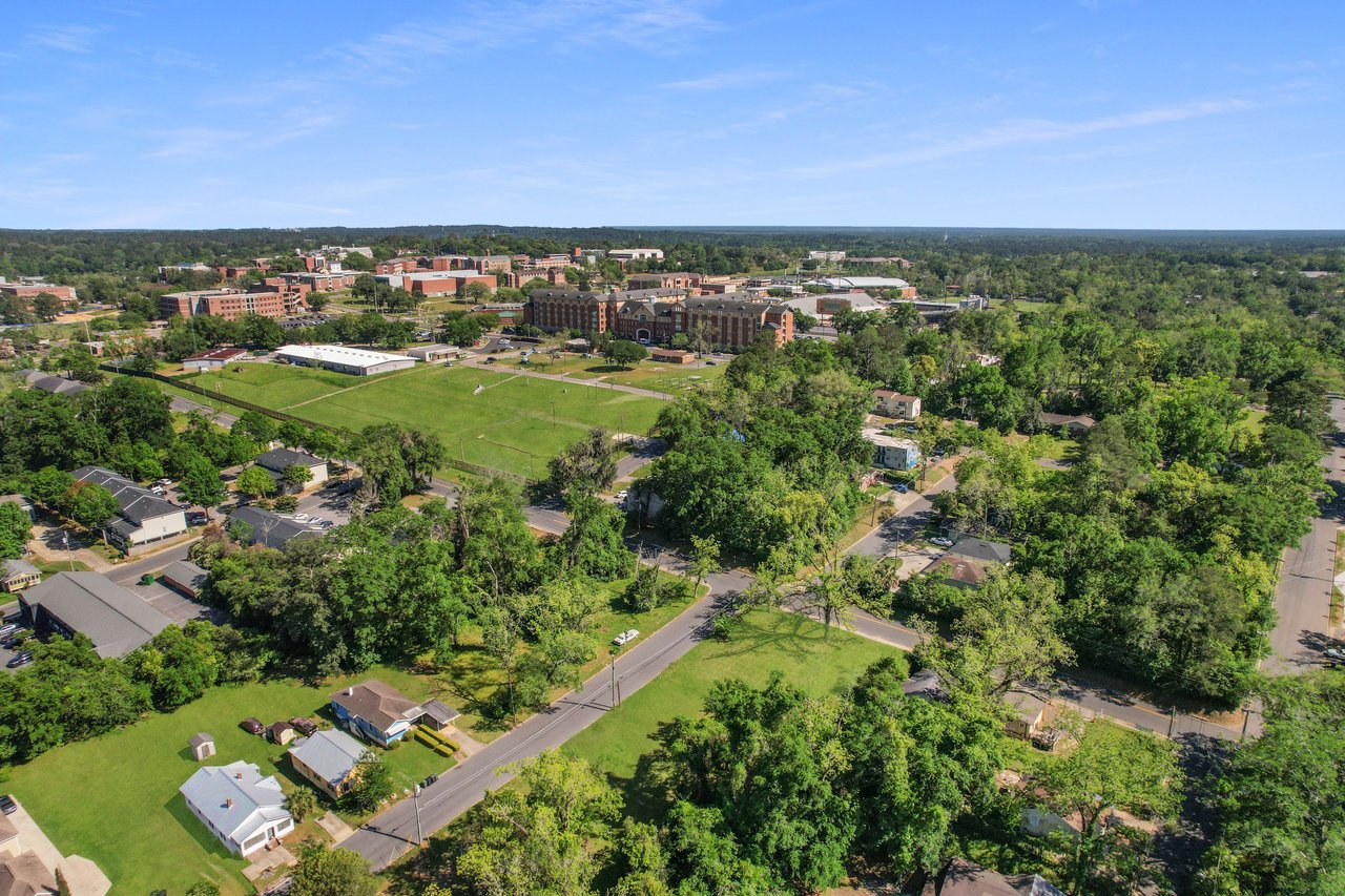 A similar aerial view of Villa Mitchell, focusing on the layout of houses, streets, and green spaces. The community seems spacious and well-maintained.