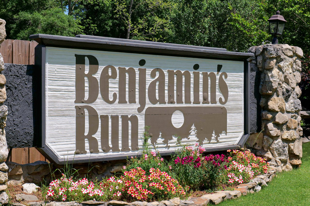 A ground-level view of the entrance sign for "Benjamin's Run," indicating the name of the residential community.