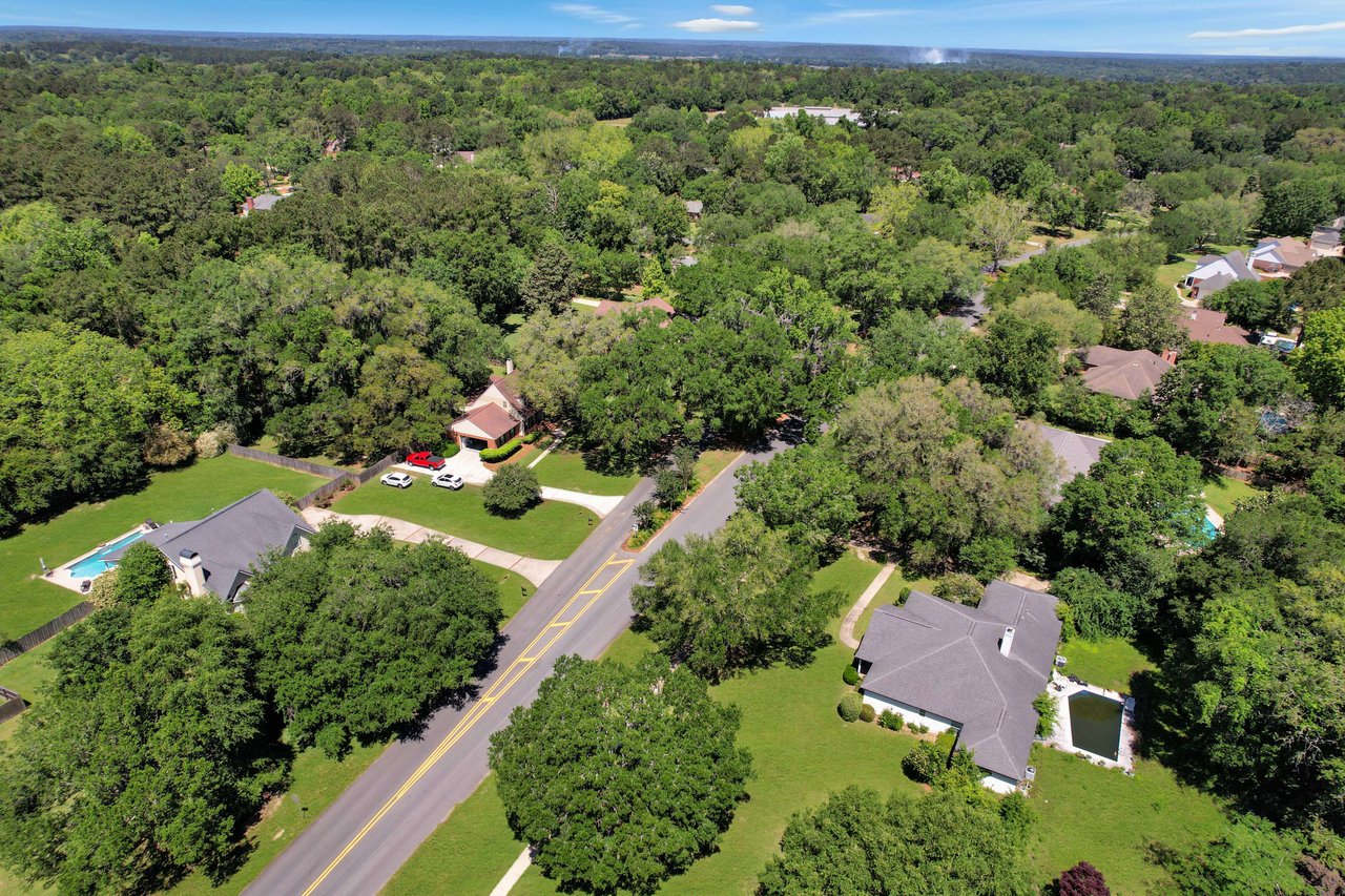 An aerial view of a residential area within the Ox Bottom Manor community, showing houses and streets surrounded by greenery.