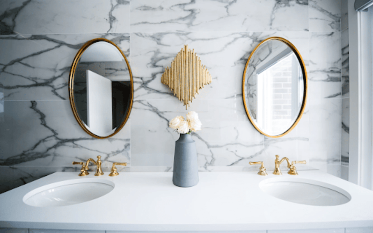 A bathroom sink with gold fixtures.