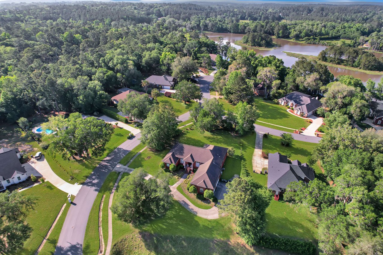 An aerial view showing the layout of houses and streets within the Summerbrooke community, surrounded by trees.