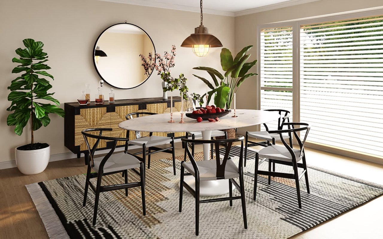 Cozy dining room with a round table, black chairs, a large mirror, and tropical indoor plants by the window.