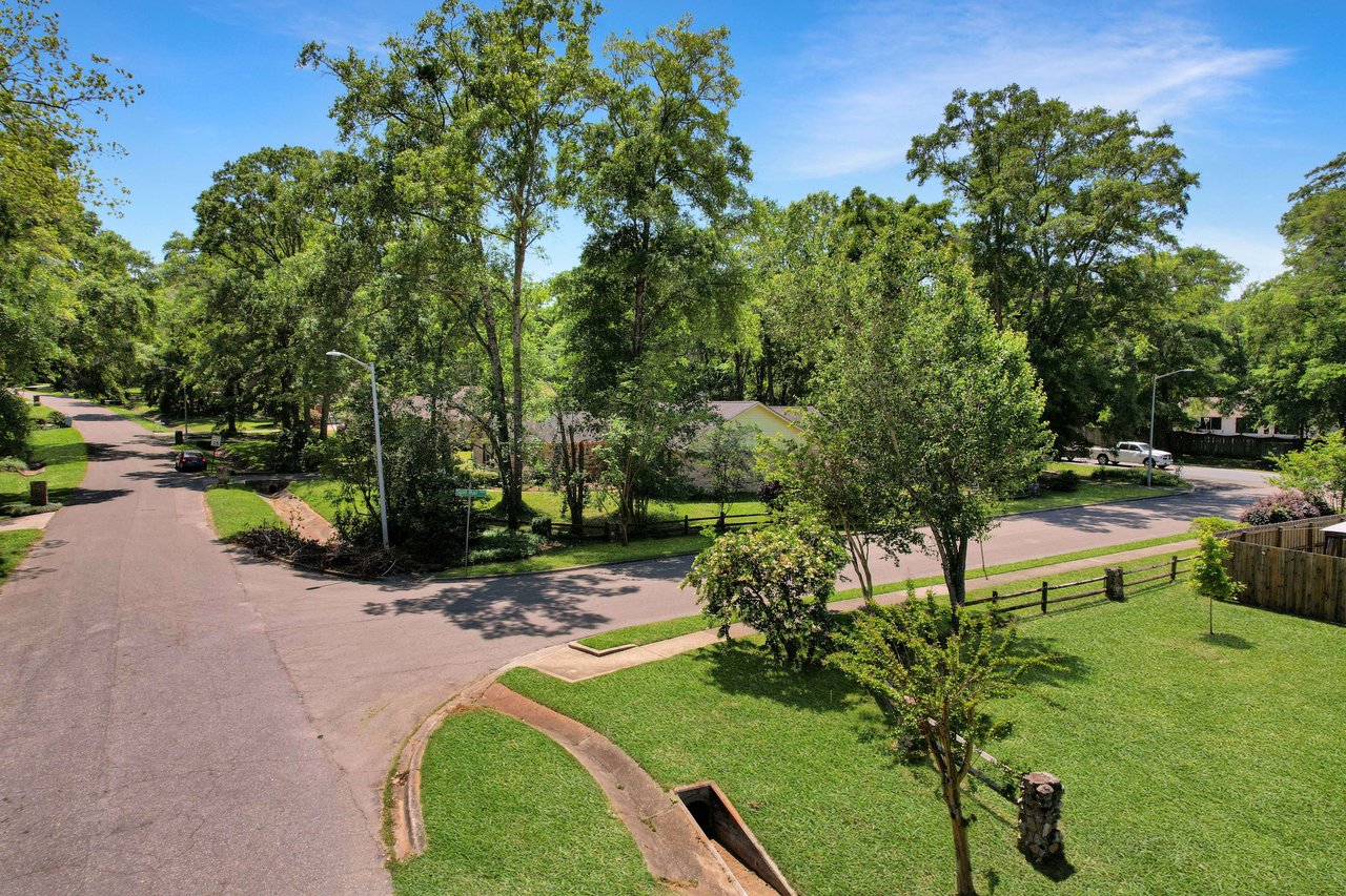 A view of a curved street in Benjamin's Run, showcasing houses, lawns, and trees.