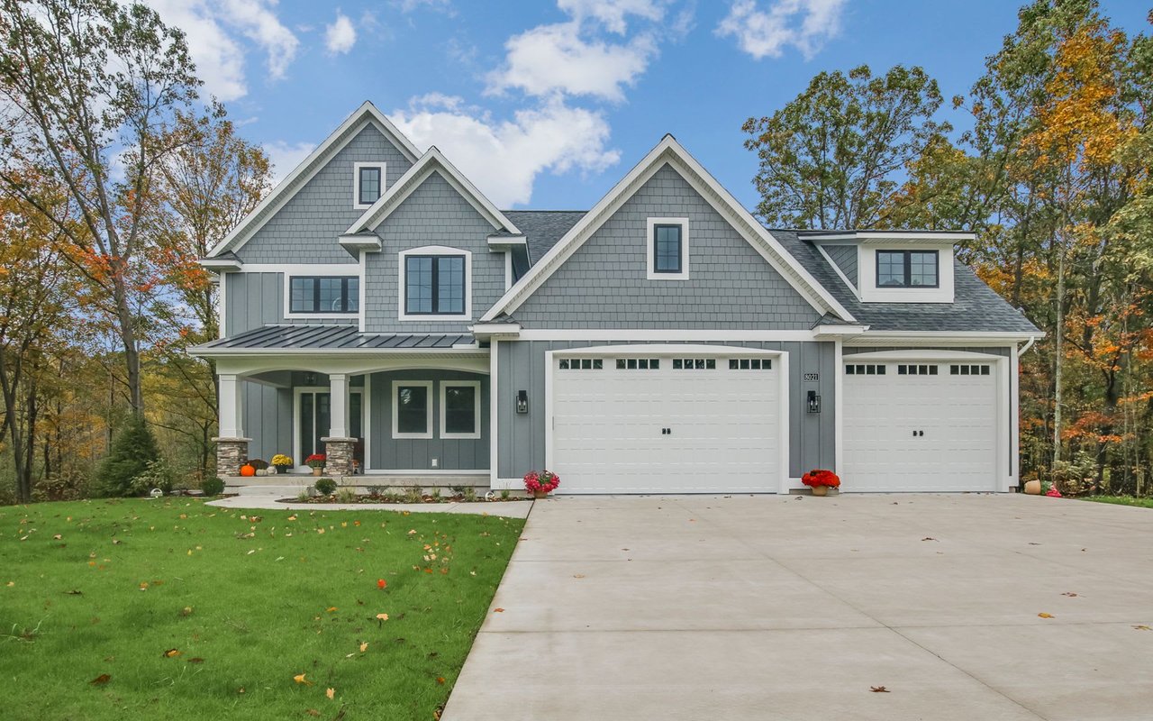 modern house painted in grey with a driveway in Forest Hills