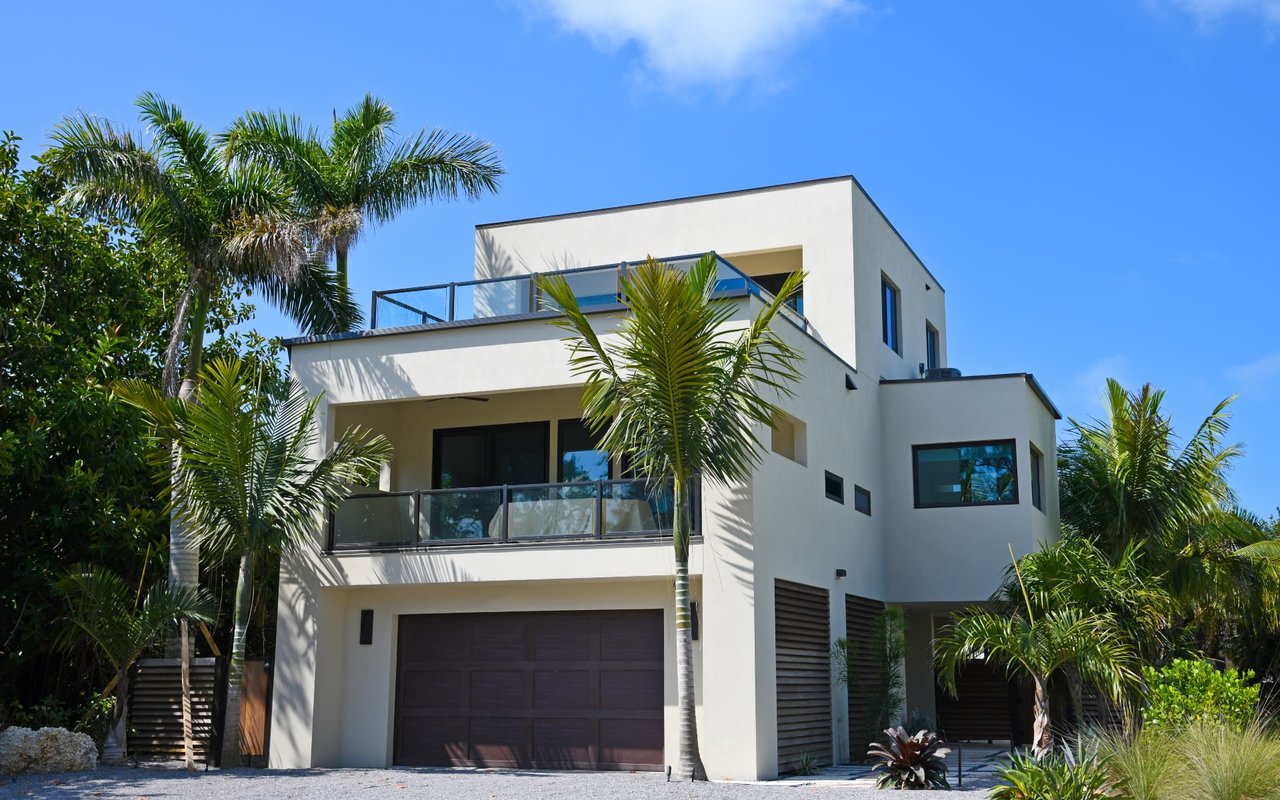  A sleek, modern two-story house with a flat roof and light-colored exterior