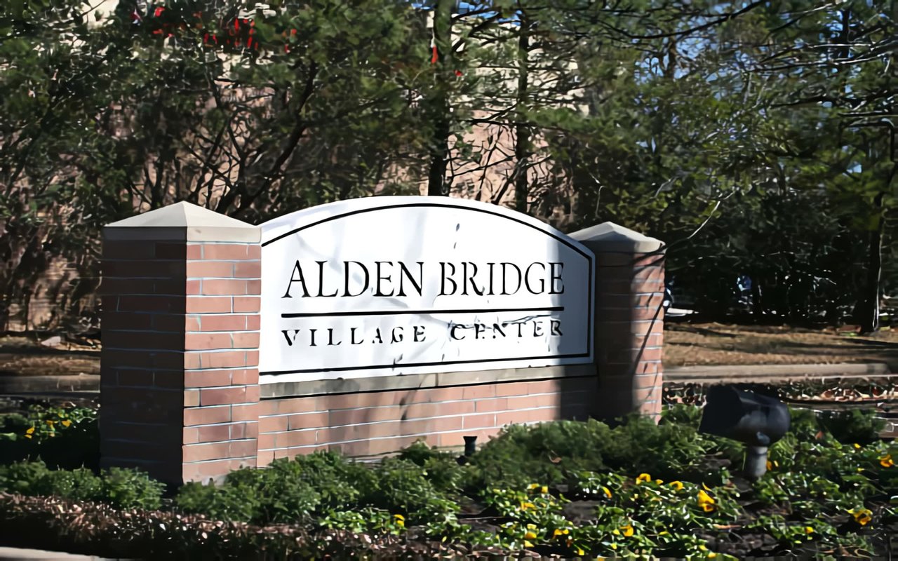  In the background, numerous green trees and bushes are visible under a bright blue sky. 