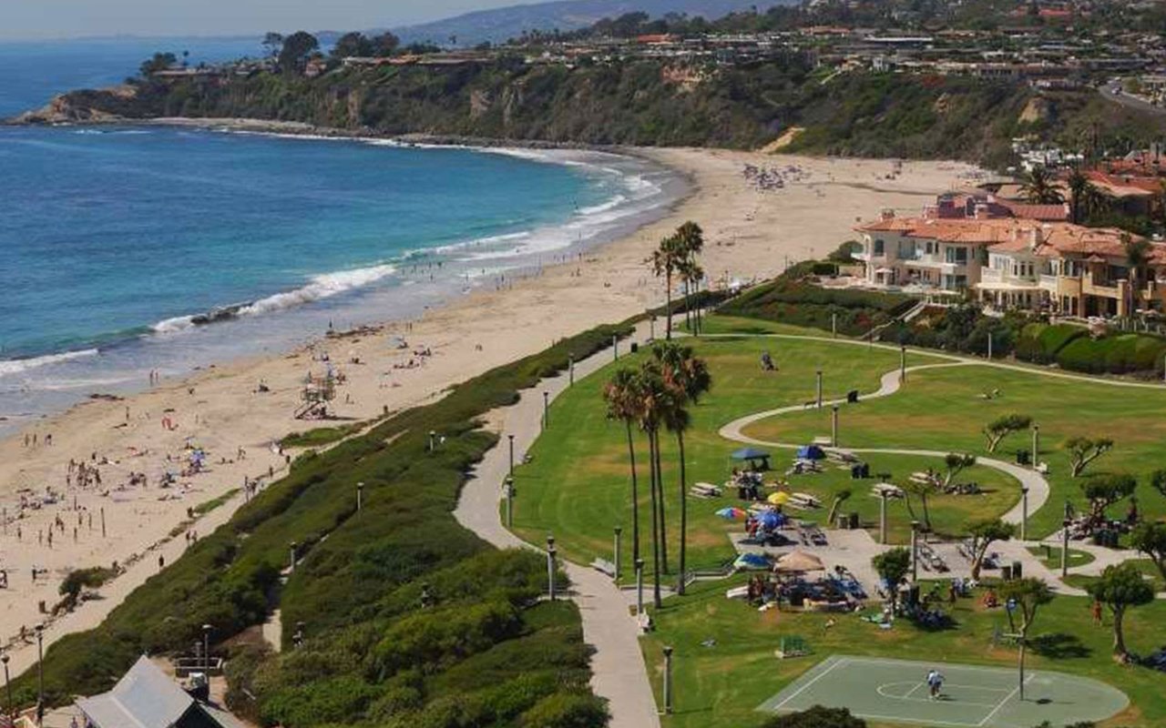 A photo of a beach and a park with luxury beachfront homes